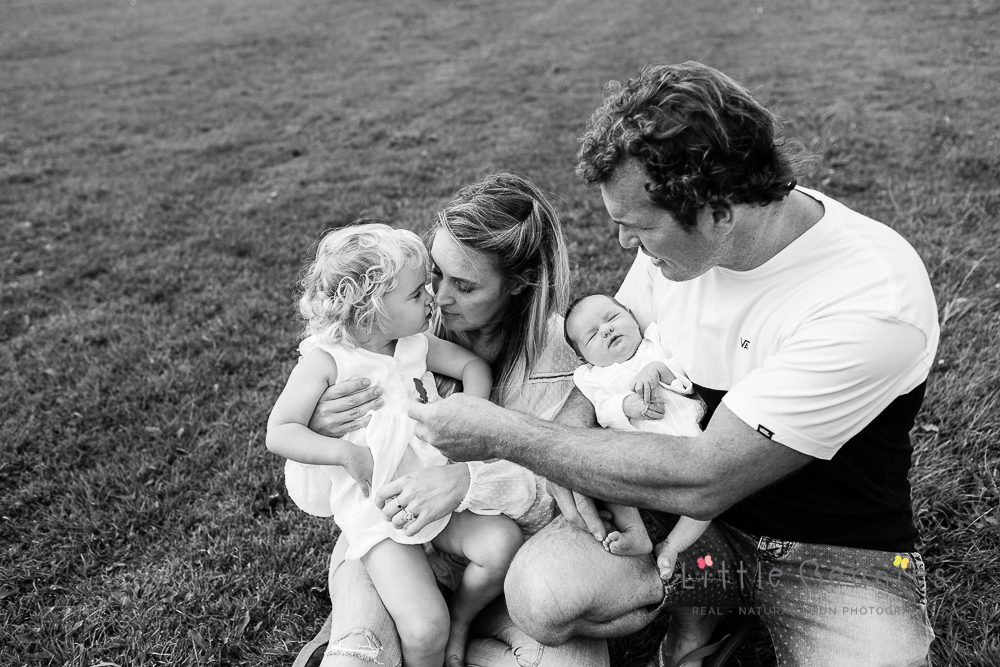 black and white photoshoot of family outside with newborn baby at home in Kenilworth