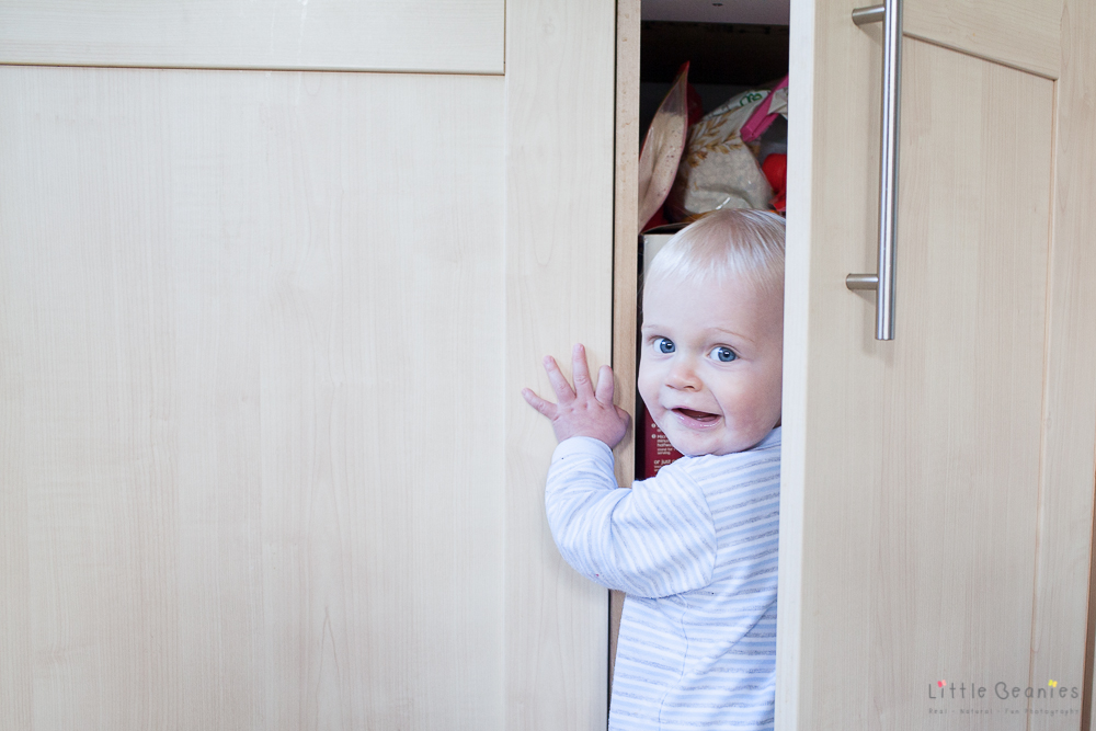 cheeky boy getting in cupboard