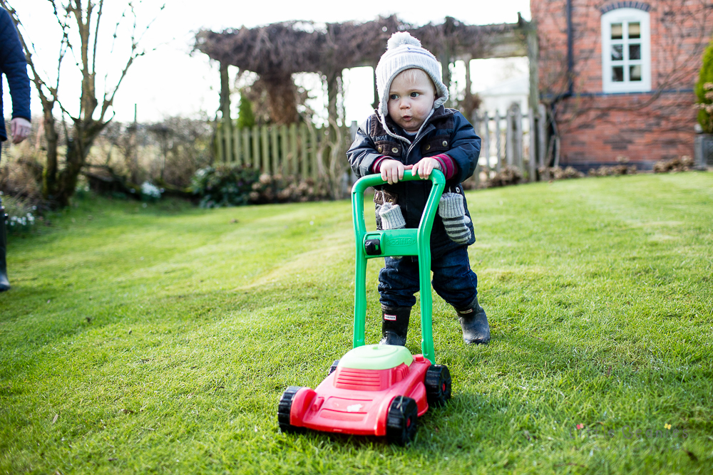 boy in garden mowing the lawn