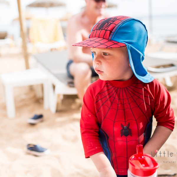 boy dressed as spiderman on the beach